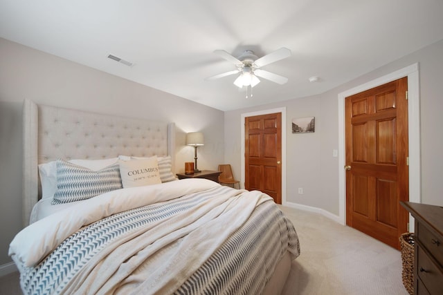 bedroom with visible vents, light colored carpet, baseboards, and ceiling fan