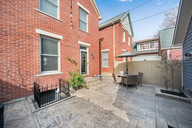 view of patio with outdoor dining space and fence