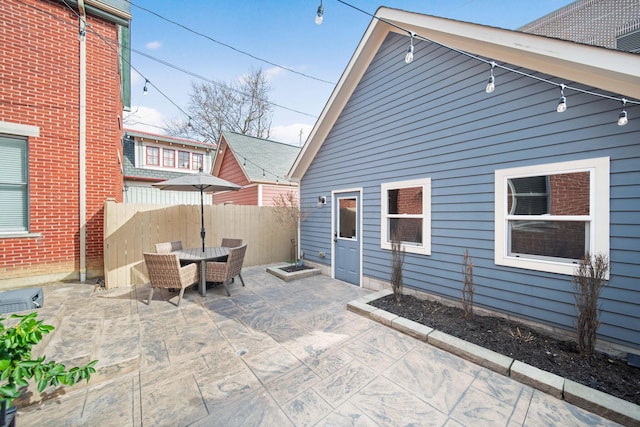 view of patio featuring outdoor dining area and fence