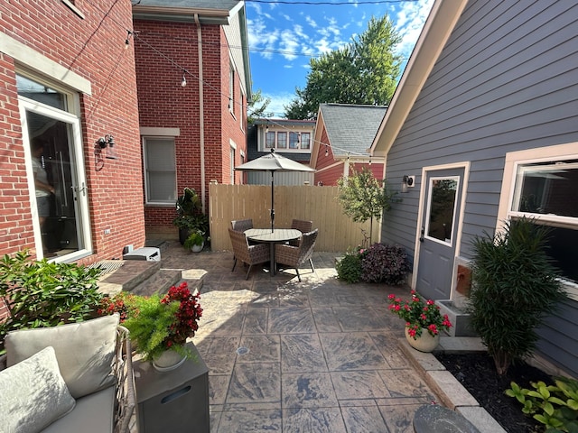 view of patio with outdoor dining area and fence