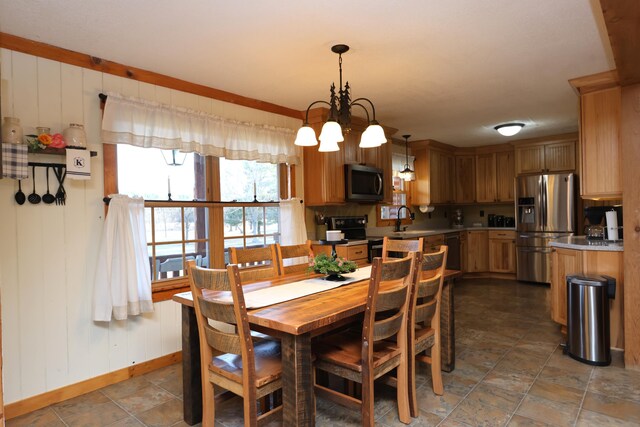 dining area with baseboards and a chandelier