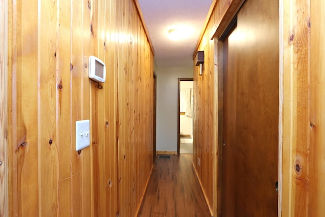 corridor with wooden walls and wood finished floors