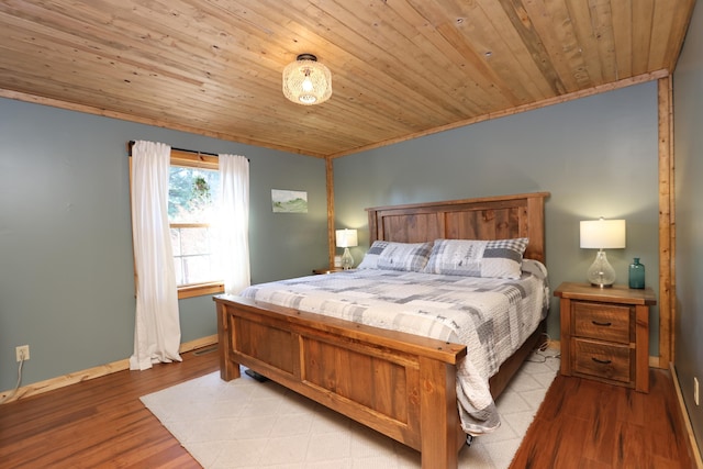 bedroom with light wood finished floors, wooden ceiling, and baseboards