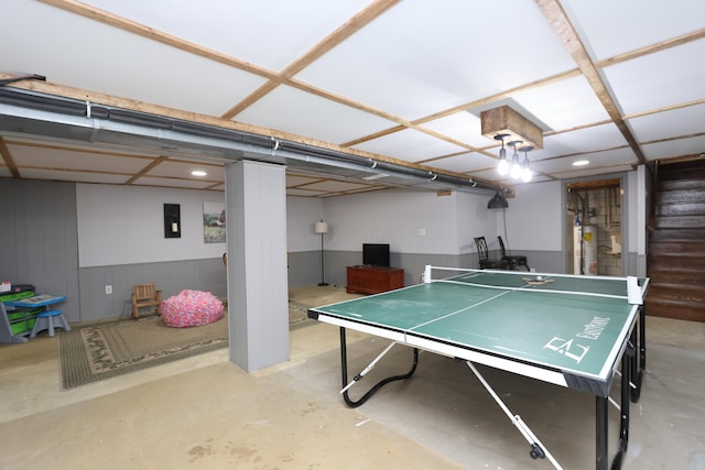 playroom with electric panel, gas water heater, and concrete floors