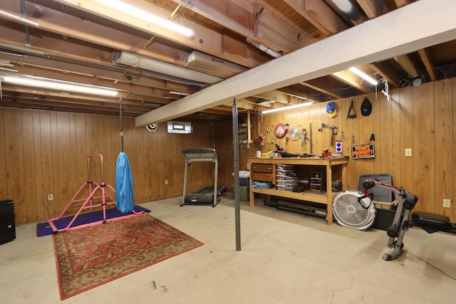 unfinished basement with a workshop area and wooden walls