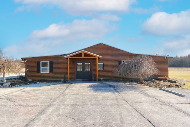 view of front facade with log veneer siding and french doors