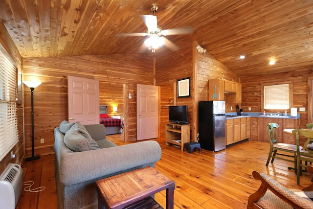 living area with a ceiling fan, light wood-style floors, wooden walls, lofted ceiling, and wood ceiling