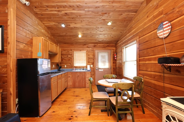 kitchen featuring wooden walls, wood ceiling, freestanding refrigerator, and vaulted ceiling