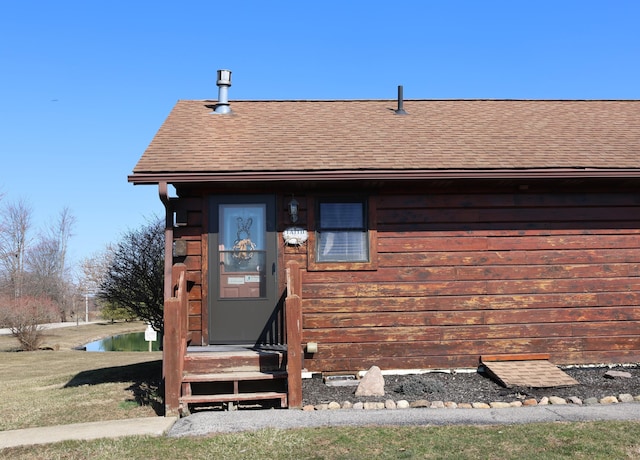 doorway to property with roof with shingles