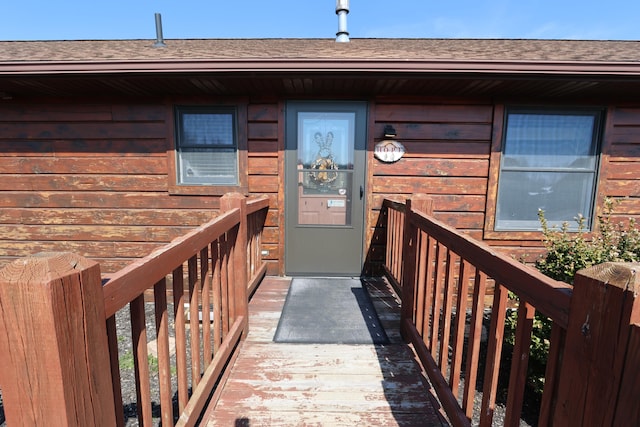 doorway to property with a shingled roof