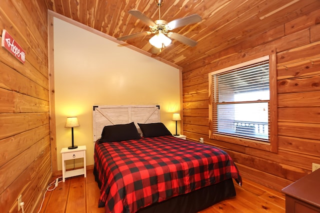 bedroom with wooden walls, wooden ceiling, and hardwood / wood-style flooring