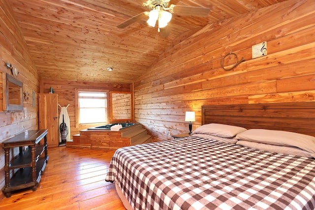 bedroom with lofted ceiling, wood ceiling, light wood-type flooring, and wood walls