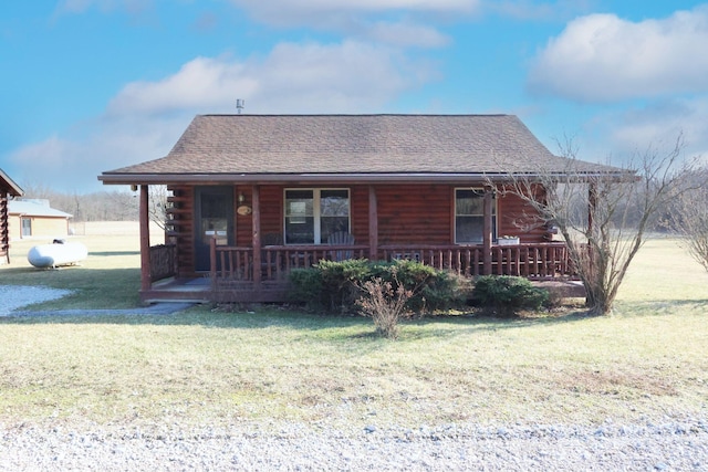 cabin featuring a porch, log exterior, a front yard, and roof with shingles