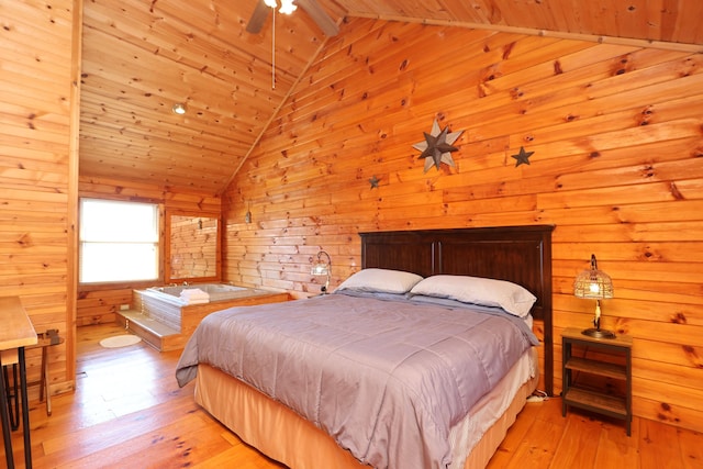 bedroom featuring wooden walls, light wood-style floors, and vaulted ceiling