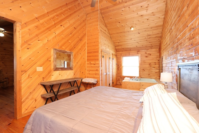 bedroom featuring wood finished floors, wood walls, and vaulted ceiling