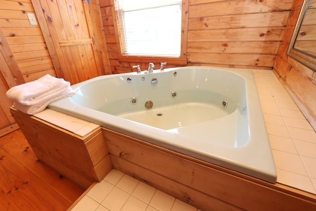 full bathroom featuring tile patterned floors, wooden walls, and a whirlpool tub