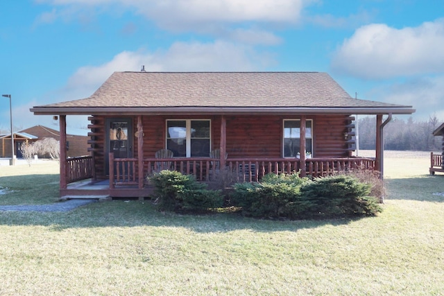 log home with a front yard, log siding, and covered porch