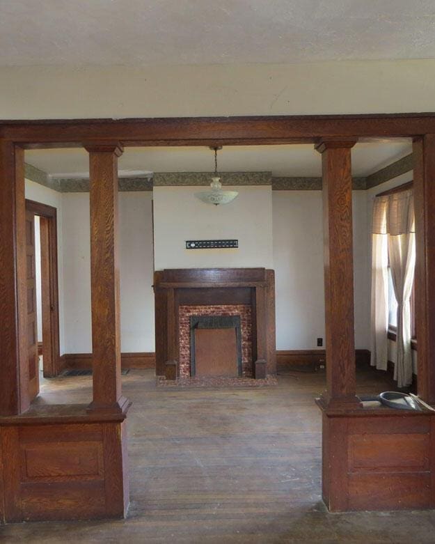 living room featuring baseboards, wood finished floors, and a fireplace