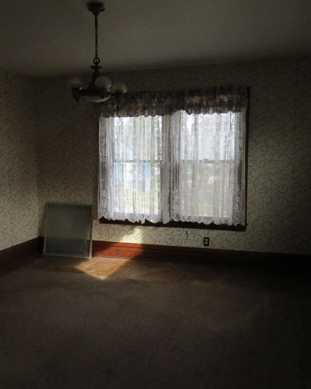 unfurnished dining area with baseboards, plenty of natural light, and wallpapered walls