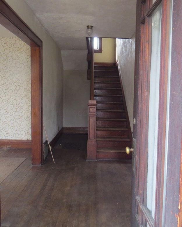 stairway featuring baseboards and hardwood / wood-style floors