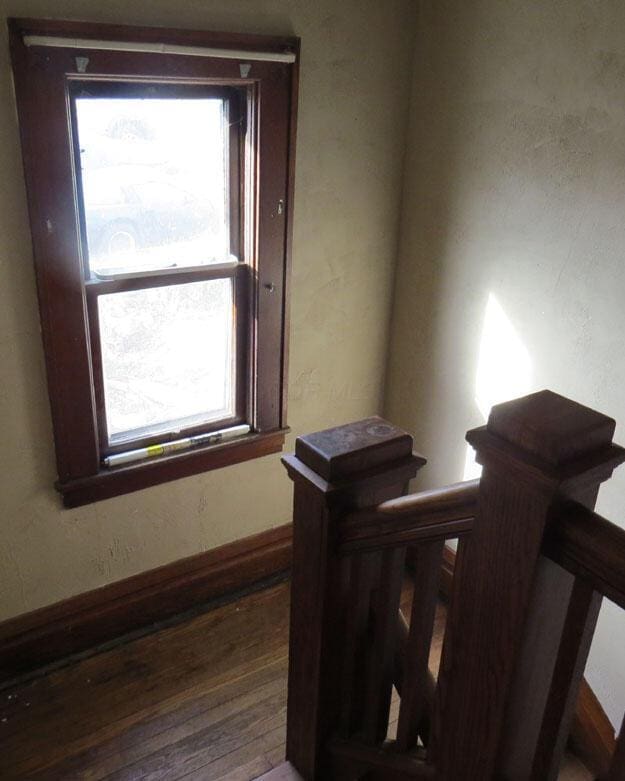 stairway featuring a wealth of natural light and wood finished floors