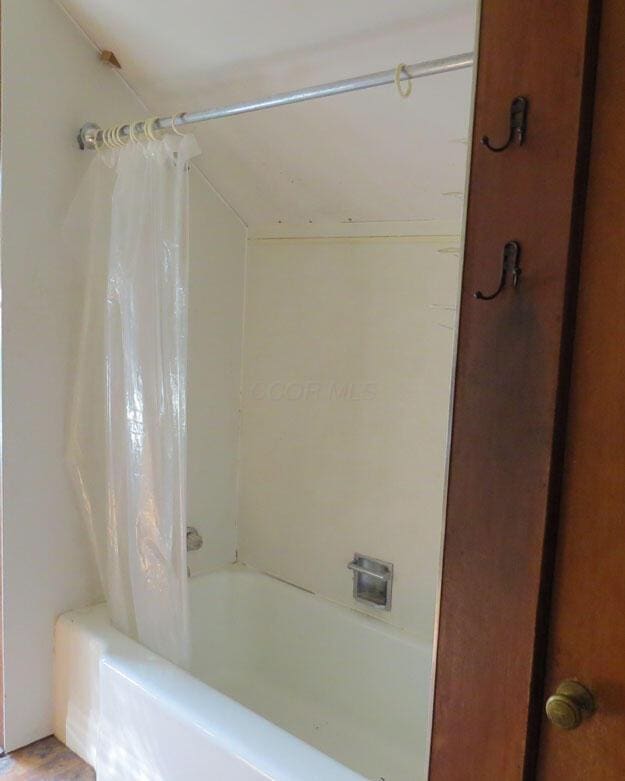 full bathroom featuring shower / bath combo with shower curtain