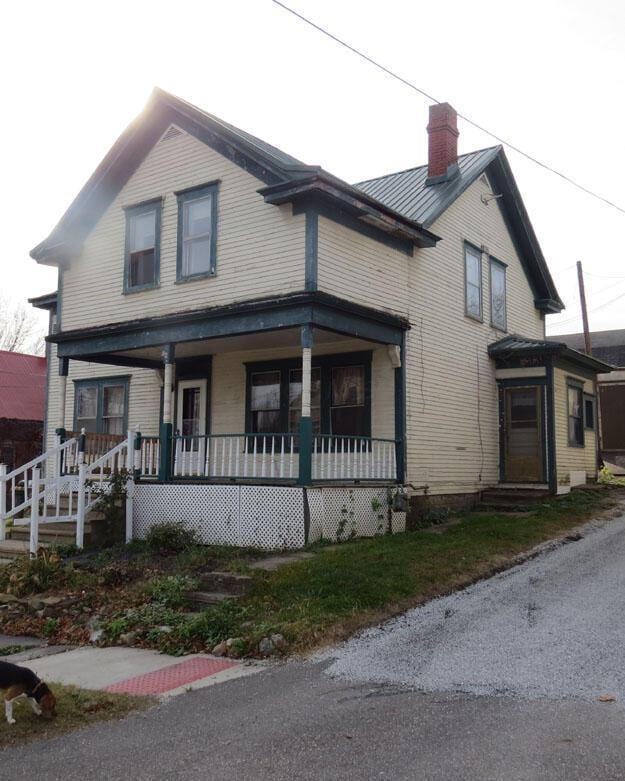 view of front of house with covered porch and a chimney