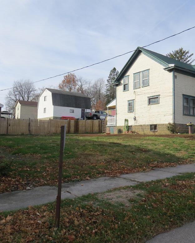 view of home's exterior featuring a lawn and fence