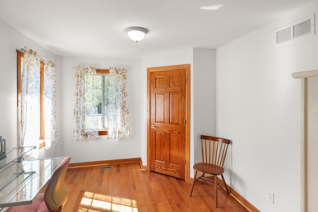 sitting room with visible vents, baseboards, and hardwood / wood-style floors