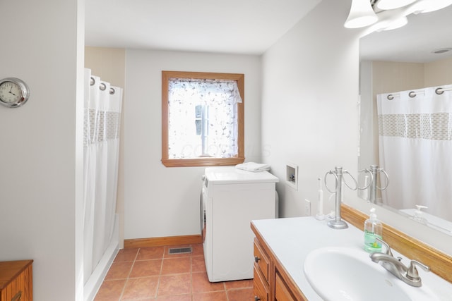 bathroom with vanity, baseboards, visible vents, washer / clothes dryer, and tile patterned floors