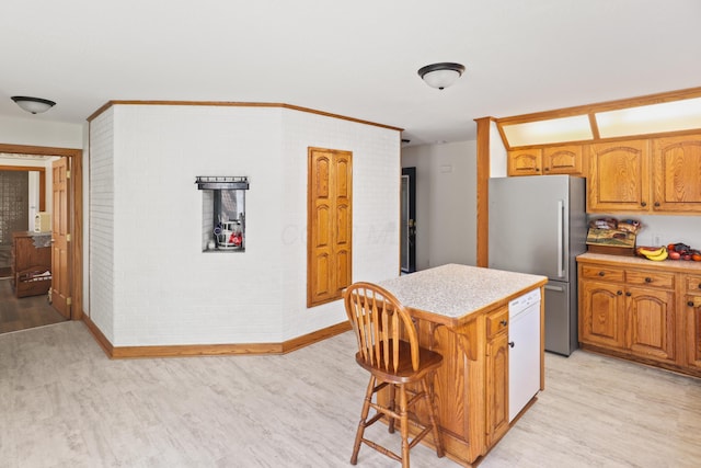 kitchen with a kitchen island, white dishwasher, freestanding refrigerator, light countertops, and light wood-type flooring