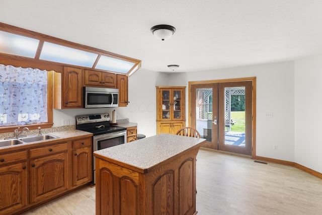 kitchen featuring visible vents, a sink, a kitchen island, stainless steel appliances, and french doors