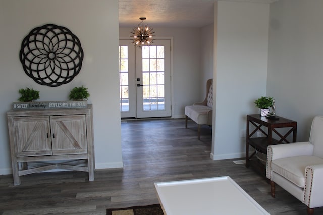 entryway featuring baseboards, dark wood-type flooring, and an inviting chandelier