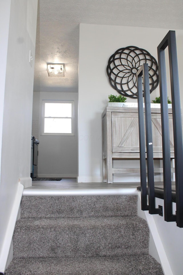 stairway featuring a textured ceiling