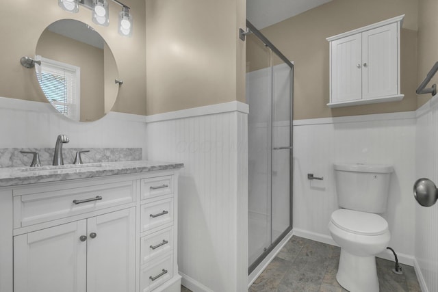 bathroom featuring a wainscoted wall, a shower stall, and vanity