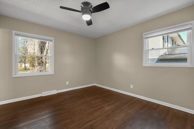 empty room featuring plenty of natural light, baseboards, and visible vents