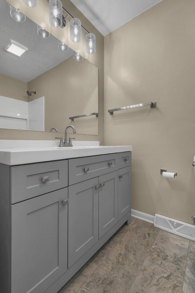 bathroom featuring vanity, baseboards, and visible vents