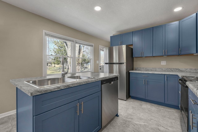 kitchen with blue cabinetry, stainless steel appliances, a textured ceiling, and a sink