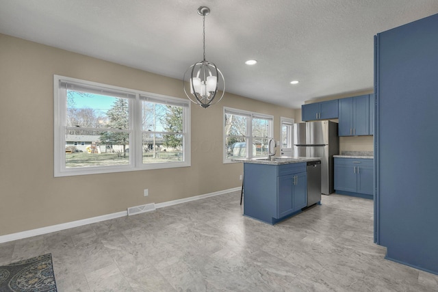 kitchen with blue cabinets, visible vents, appliances with stainless steel finishes, and an inviting chandelier