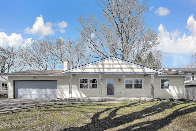 view of front of property featuring a front yard, a garage, driveway, and a chimney