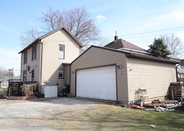 view of home's exterior with gravel driveway and an attached garage