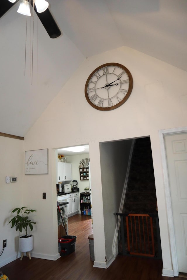 interior space with baseboards, lofted ceiling, dark wood-type flooring, and a ceiling fan