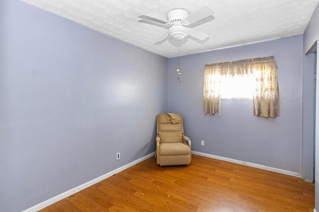 unfurnished room with ceiling fan, baseboards, a textured ceiling, and wood finished floors