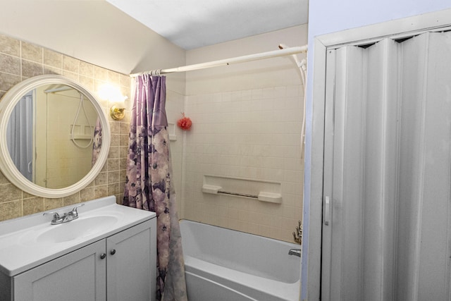 bathroom featuring backsplash, tile walls, shower / bath combo, and vanity