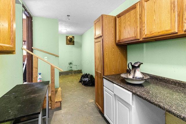 kitchen with dark stone counters and unfinished concrete floors