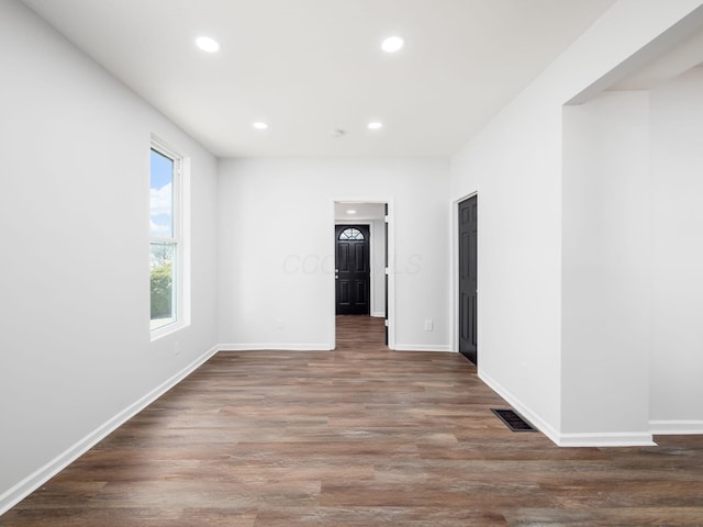 empty room with recessed lighting, wood finished floors, visible vents, and baseboards