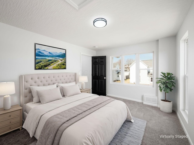 bedroom featuring visible vents, a textured ceiling, baseboards, and carpet