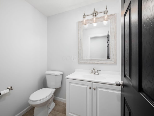 bathroom featuring vanity, toilet, and baseboards