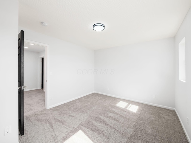 unfurnished room featuring baseboards and carpet flooring