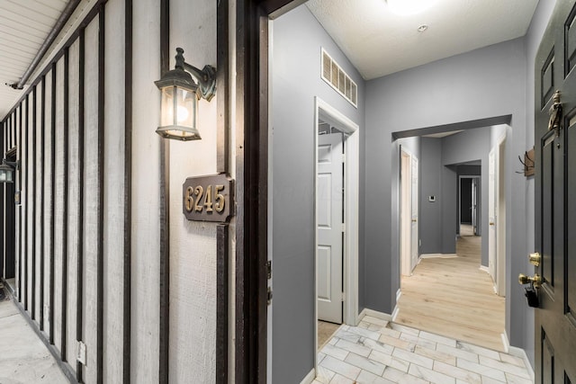 corridor with visible vents and baseboards